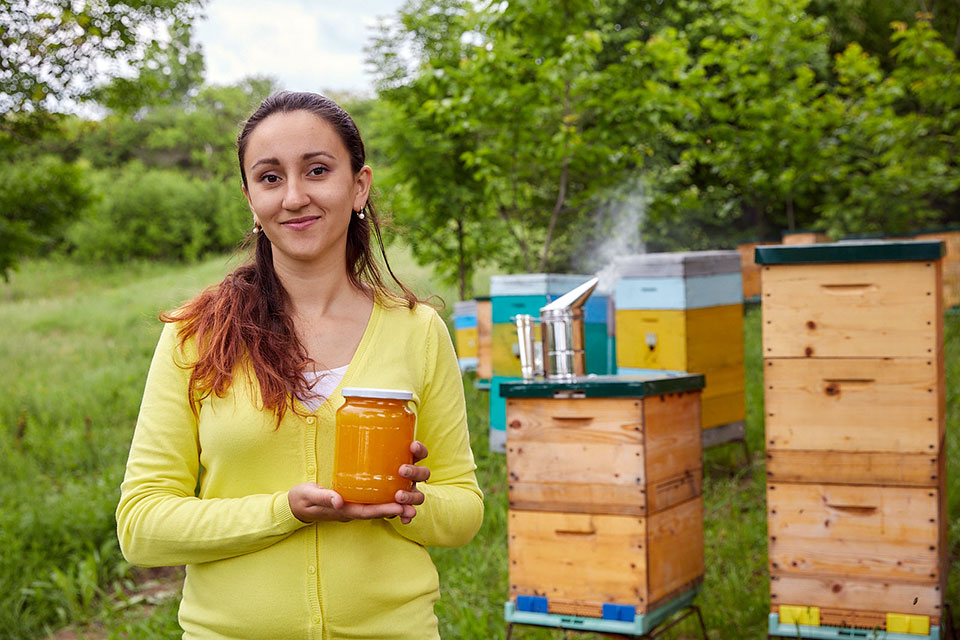 Victoria Sobol stands with her beehives . Photo: UN Women/Aurel Obreja