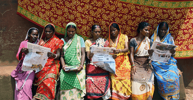 Mujeres recién alfabetizadas leyendo periódicos en un centro de alfabetización en Bengala Occidental, India, apoyado por Asistencia Profesional para Acción por el Desarrollo (PRADAN), beneficiaria del FIG. Foto: Asistencia Profesional para Acción por el Desarrollo/Sourangshu Banerjee.