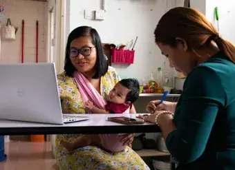 Deborah and Kip, from the Myanmar Ethnic Women Refugee Organization, conducting a virtual support group session with other refugee women.  © UNHCR/Patricia Krivanek