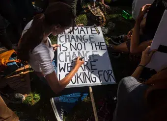 A young woman in New York prepares a protest sign as part of the youth-lead global Climate Strike in September 2019.   Photo: UN Women/Amanda Voisard