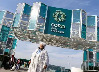 A COP29 attendee stands outside the venue in Baku, Azerbaijan. Photo: UN Climate Change/Kiara Worth.