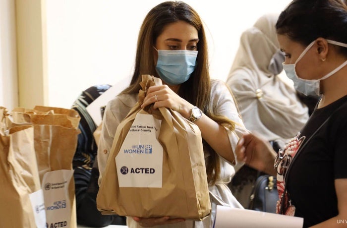 Workers on behalf of ACTED and UN Women distribute COVID-19 hygiene and dignity kits for women and girls in Tripoli, Lebanon. Photo: UN Women.