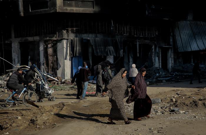 Two women cross the road and are surrounded by destroyed buildings on al-Jalaa Street in the centre of Gaza City on 11 January 2024. 