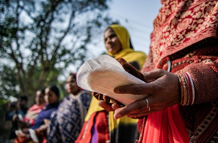 In Sitamarhi State, Bihar, India, in 2022, women hold sanitary pads during an awareness campaign as part of a menstrual hygiene management program organized by UNICEF.
