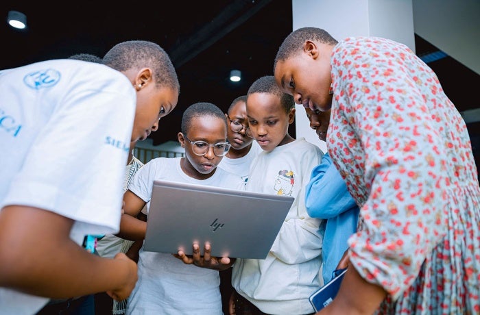 Young women participants work together on a laptop at during an African Girls Can Code Initiative's coding bootcamp held at the GIZ Digital Transformation Center in Kigali, Rwanda in April 2024