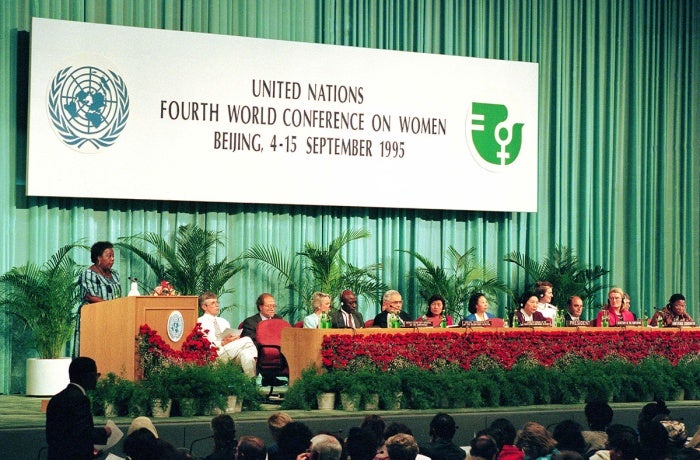 Gertrude Mongella (à gauche, debout sur l’estrade), Secrétaire générale de la Conférence, prend la parole lors de la session du 4 septembre 1995.  Photo : Photo ONU/Milton Grant