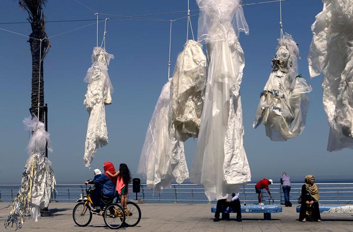 In Lebanon, activists hung tattered wedding dresses outside public buildings in order to draw attention to laws that forced women to marry their rapists. Photo: ABAAD by Patrick Baz /AFP