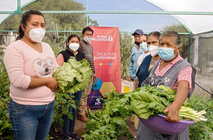 Participants from the Sembrando Esperanza (Sowing Hope) module in San Cristóbal Tepeteopán  pose for a photo with vegetables from their greenhouse.  Some in the program sell the vegetables they harvest, others use the produce to feed their families. Photo