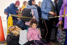 A young girl looks sits with luggage alongside a crowd of refugees at the Mayaki-Udobnoe Border crossing in southeastern Moldova. 