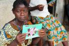 woman in Sierra Leone holding Ebola info card