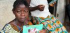 woman in Sierra Leone holds Ebola info card